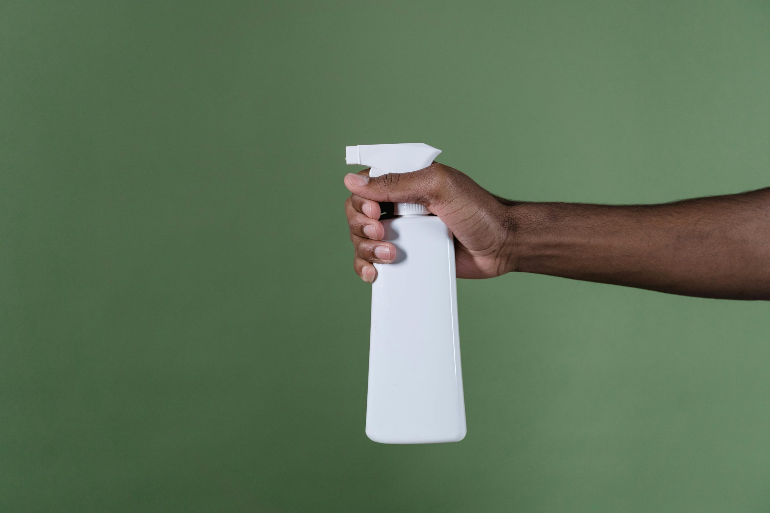 close-up of hand holding a white sprayer